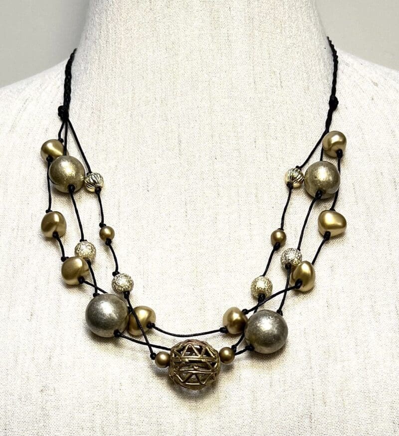 Old gold and other gold beads on black string 3-strand necklace (N-391)