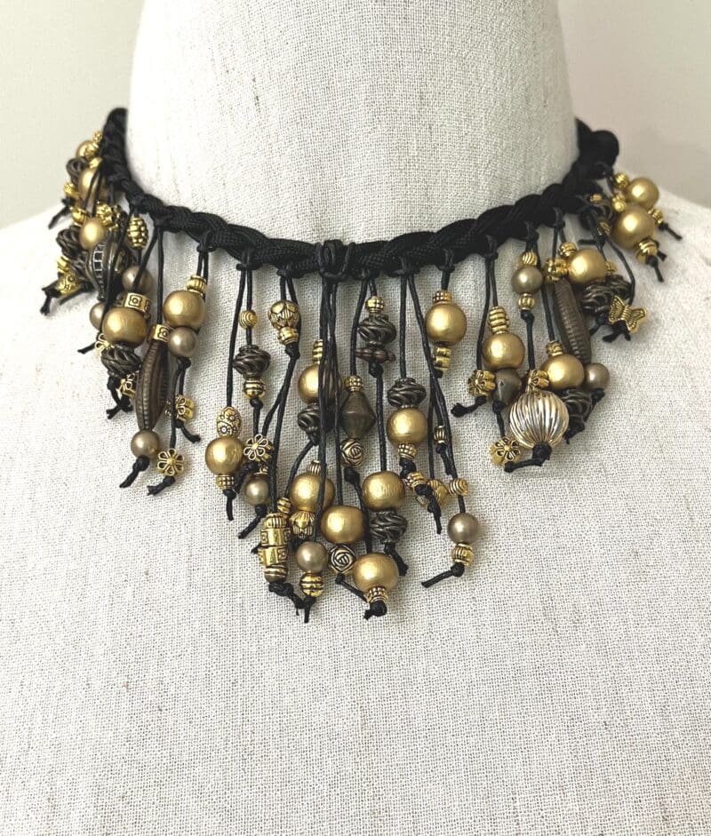 A variety of small gold beads on black string and cord dangle necklace (N-230)